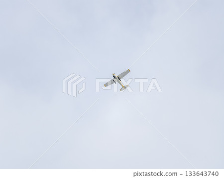 Small ultralight airplane with overhead wing and single propeller flying in sunset sky. Small ultralight airplane with overhead wing and single propeller flying in sunset sky. 133643740