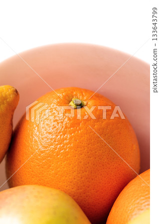 A ripe orange among fruits in a ceramic bowl A ripe orange among fruits in a ceramic bowl 133643799