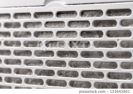 Plastic filter of home air conditioning appliance contaminated with grey house dust fibres Plastic filter of home air conditioning appliance contaminated with grey house dust fibres 133643801
