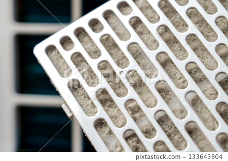 Plastic filter grille of home ventilation air purifier contaminated with grey house dust fibers Plastic filter grille of home ventilation air purifier contaminated with grey house dust fibers 133643804