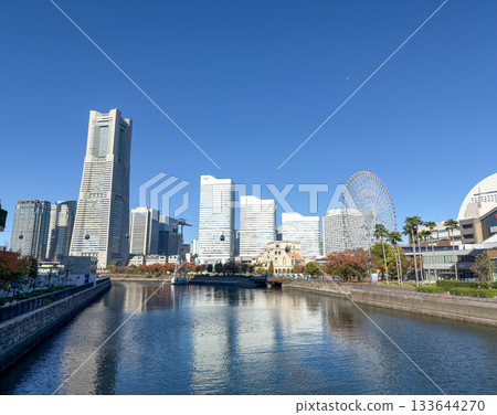 Clear blue sky and the reflection of the Minato Mirai buildings on the water surface. November 2025, Yokohama, Japan 133644270