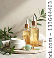 Premium natural skincare display featuring golden oil serum bottles, white cream jar, and jade gua sha on a minimal stone surface. Premium natural skincare display featuring golden oil serum bottles, white cream jar, and jade gua sha on a minimal stone surface. 133644463