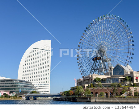 A yellow water bus runs along the waterway between the buildings of Minato Mirai. November 2025, Yokohama, Japan A yellow water bus runs along the waterway between the buildings of Minato Mirai. November 2025, Yokohama, Japan 133644494