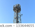 A base station tower shining against the blue sky 133644655