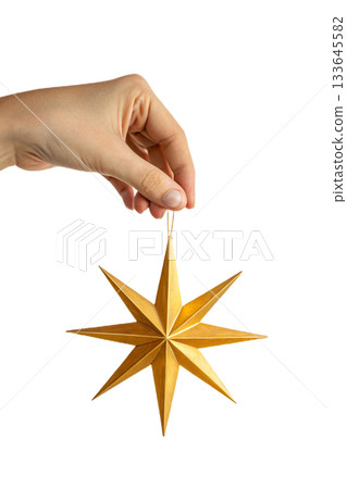 Concept of guidance and celebration with hand presenting pristine golden star ornament for christmas and new year themes 133645582