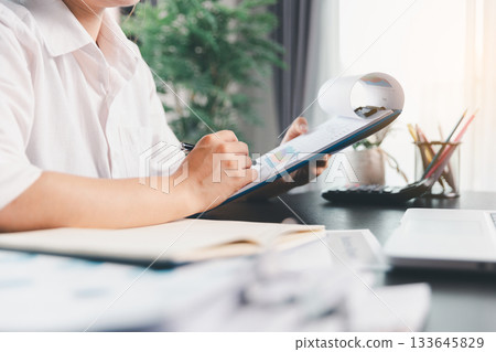 Business woman analyze calculate company financial, tax results office accounting statistics analytical research. calculating business balance prepare tax reduction. Tax deduction planning concept. Business woman analyze calculate company financial, tax results office accounting statistics analytical research. calculating business balance prepare tax reduction. Tax deduction planning concept. 133645829