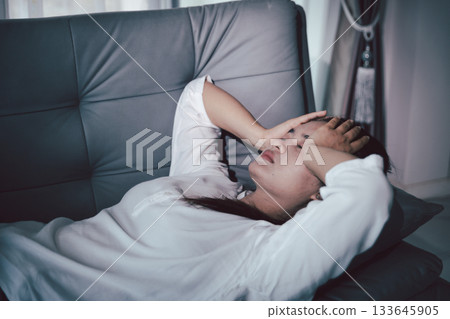 Sorrowful woman sat alone, overwhelmed by emotion, her sad and unhappy expression revealing deep despair, stress and distress left feeling depressed. sorrowful sad, despair alone, depressed stress 133645905