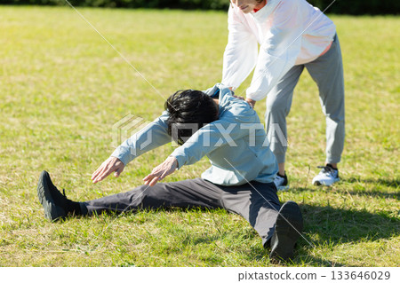 Middle-aged couple doing stretching exercises outdoors 133646029