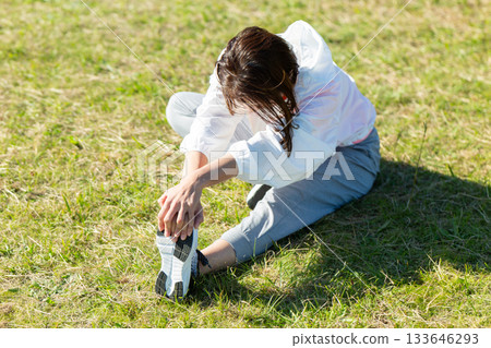 Middle-aged woman doing stretching exercises outdoors 133646293