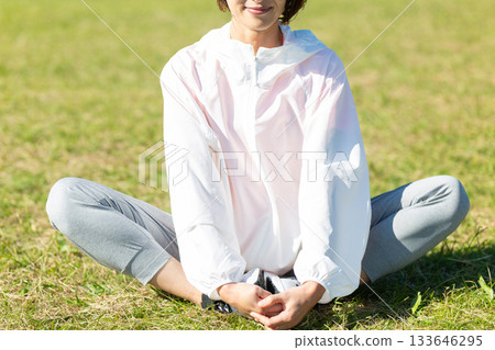 Middle-aged woman doing stretching exercises outdoors 133646295