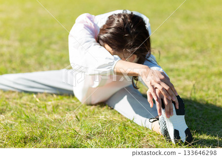 Middle-aged woman doing stretching exercises outdoors Middle-aged woman doing stretching exercises outdoors 133646298