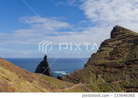 Scenic hiking path through rocky Sao Lourenco landscape with layered cliffs and deep blue ocean Scenic hiking path through rocky Sao Lourenco landscape with layered cliffs and deep blue ocean 133646368