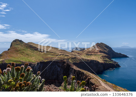 Sao Lourenco shows rugged volcanic slopes dry terrain and deep blue Atlantic under clear sky Sao Lourenco shows rugged volcanic slopes dry terrain and deep blue Atlantic under clear sky 133646376