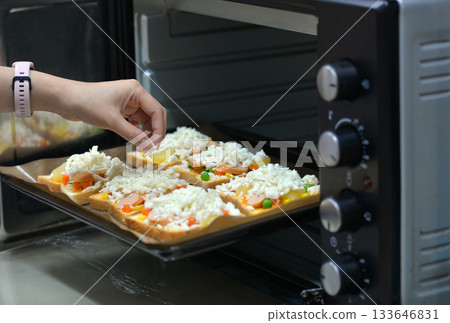 home cooking With slices of bread, topped with cheese, sausage, ham, beans and carrots, ready to bake in the electric oven. home cooking With slices of bread, topped with cheese, sausage, ham, beans and carrots, ready to bake in the electric oven. 133646831