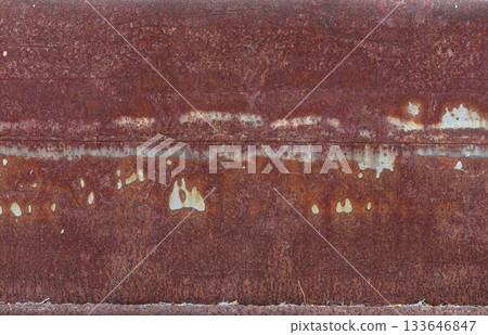 The metal panel is made of iron and has been weathered over time, resulting in a rough and textured surface. The rust has formed in a red color, giving the panel a grunge and industrial feel. 133646847