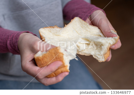 A person holding soft bread A person holding soft bread 133646977