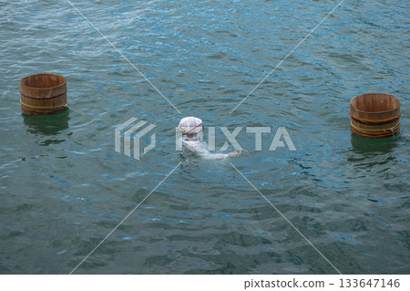 Ama Divers of Ise Shima fishing tradition in Mie Prefecture, Japan Person swimming in natural hot spring with wooden tubs floating nearby 133647146