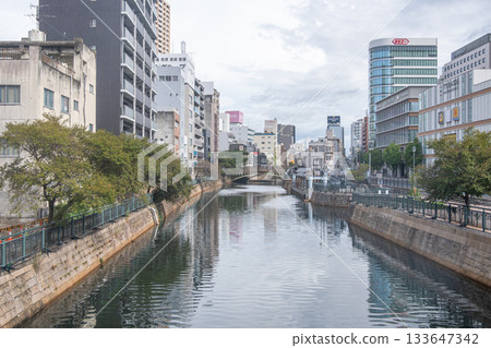 Nagoya, Japan - Sep 19, 2024 : Urban river flowing through city with buildings and trees on both sides 133647342