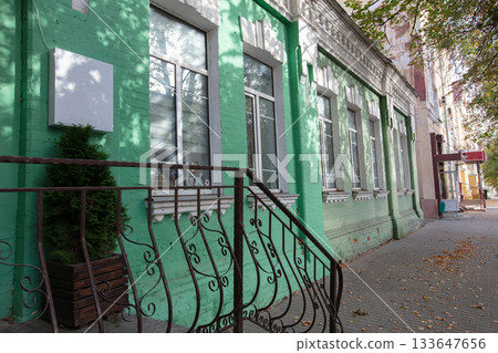 Bright green building with windows and a railing in urban setting Bright green building with windows and a railing in urban setting 133647656