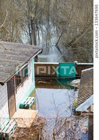 Spring flood. Flooded house from the plots due to the spring river flood. Spring flood. Flooded house from the plots due to the spring river flood. 133647698