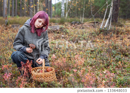Girl foraging wild mushrooms in autumn forest 133648033