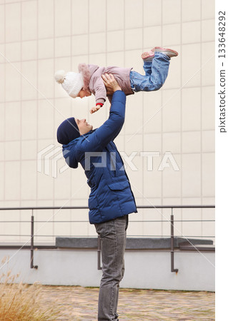 Father and daughter enjoying a playful moment, showing family love and connection 133648292