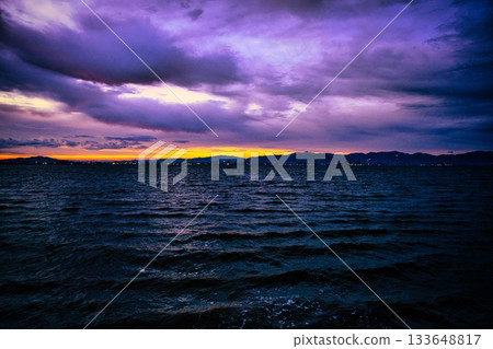 A fantastical sunrise over the sea, where purple and orange intersect A fantastical sunrise over the sea, where purple and orange intersect 133648817