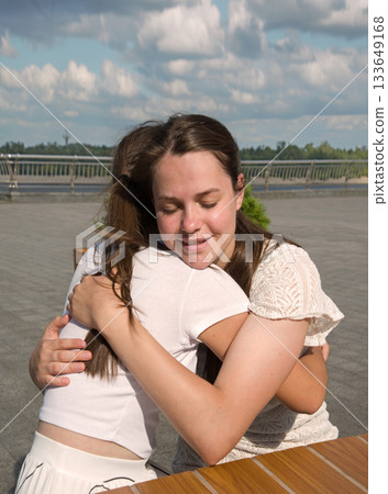 Two girls hugging in the cafe Two girls hugging in the cafe 133649168
