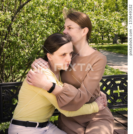 Two girls hug one another Two girls hug one another 133649182