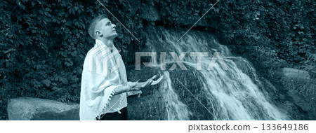 Young guy at old waterfall Young guy at old waterfall 133649186