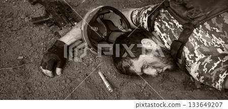 Wounded soldier laying on the ground 133649207
