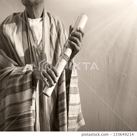 Male hand holding an old scroll Male hand holding an old scroll 133649214