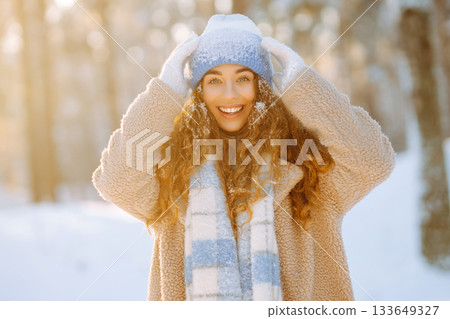 Laughing beautiful woman in the winter forest enjoying an amazing sunset. Walking concept. Laughing beautiful woman in the winter forest enjoying an amazing sunset. Walking concept. 133649327