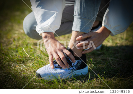 Middle-aged woman hurting her ankle while exercising outdoors 133649536