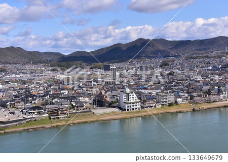 日本愛知縣犬山市：春天的犬山城，櫻花盛開。從國寶級城堡塔樓的頂層俯瞰周圍的城市景觀和自然風光。 133649679