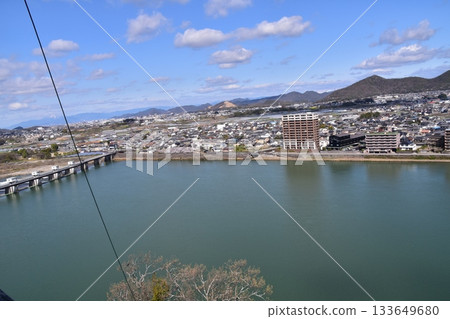 日本愛知縣犬山市：春天的犬山城，櫻花盛開。從國寶級城堡塔樓的頂層俯瞰周圍的城市景觀和自然風光。 133649680