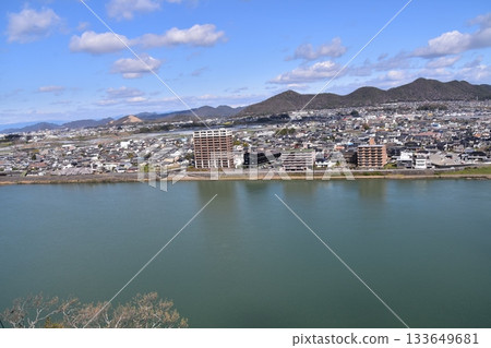 日本愛知縣犬山市：春天的犬山城，櫻花盛開。從國寶級城堡塔樓的頂層俯瞰周圍的城市景觀和自然風光。 133649681