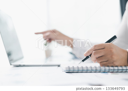 Concept of business planning and financial analysis. A businesswoman writes notes on documents with charts and reports, using laptop and calculator for budget management at modern office desk. Concept of business planning and financial analysis. A businesswoman writes notes on documents with charts and reports, using laptop and calculator for budget management at modern office desk. 133649793