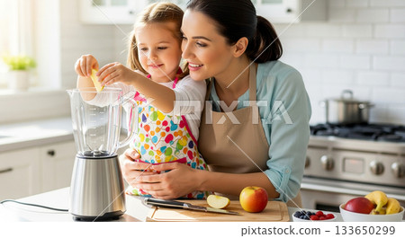 A mother and daughter are making a fruit smoothie together using a blender. 133650299