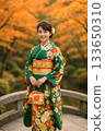 Portrait of a woman in a green kimono and a Japanese garden in autumn 133650310