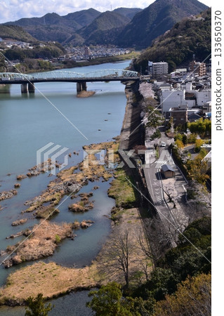Inuyama City, Aichi Prefecture, Japan: Inuyama Castle in spring and cherry blossoms in full bloom. View from the top floor of the national treasure castle tower, the surrounding cityscape and nature. Inuyama City, Aichi Prefecture, Japan: Inuyama Castle in spring and cherry blossoms in full bloom. View from the top floor of the national treasure castle tower, the surrounding cityscape and nature. 133650370