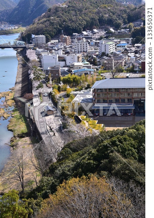 Inuyama City, Aichi Prefecture, Japan: Inuyama Castle in spring and cherry blossoms in full bloom. View from the top floor of the national treasure castle tower, the surrounding cityscape and nature. 133650371