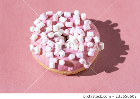 Pink frosted donut with marshmallow toppings on pastel pink background 133650602