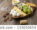 Gourmet cheese board with grapes and crackers on rustic wood background 133650654