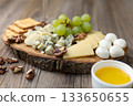 Gourmet cheese board with grapes and crackers on rustic wood background 133650655