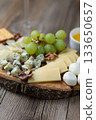 Gourmet cheese board with grapes and crackers on rustic wood background 133650657