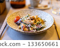 Fresh caesar salad with grilled chicken and cherry tomatoes in rustic ceramic bowl 133650661