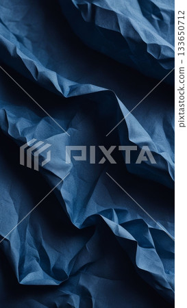 Blue wrinkled paper texture with soft shadows and flowing folds, abstract background for design, craft, and creative projects. Blue wrinkled paper texture with soft shadows and flowing folds, abstract background for design, craft, and creative projects. 133650712