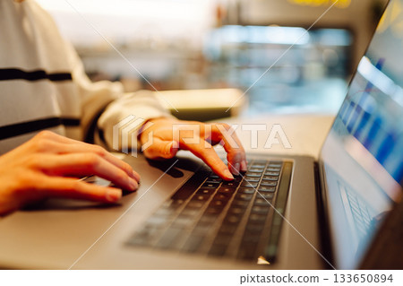 A young woman is engaged in typing on a laptop. Cyber security. Business, Freelance, Shopping 133650894