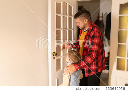 Father teaching son about safety entering returning home Father teaching son about safety entering returning home 133650956